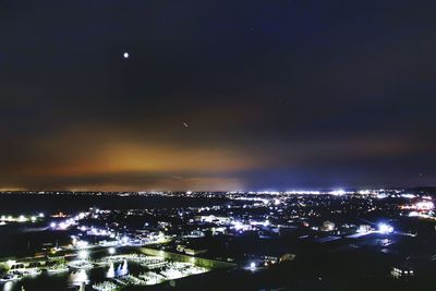 Illuminated cityscape against sky at night