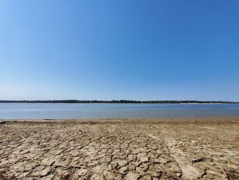 Scenic view of beach against clear blue sky