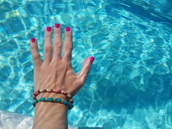 Cropped hand of woman in swimming pool