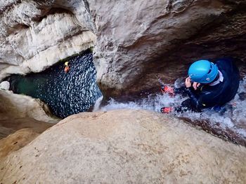 Man standing on rock by water