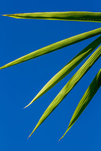 Low angle view of wind turbine against clear blue sky