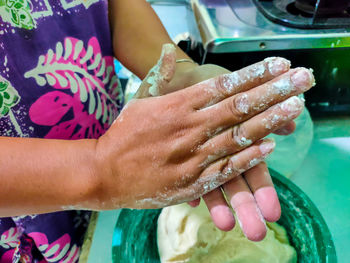 Midsection of woman with hands in water