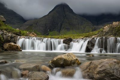 Scenic view of waterfall against sky