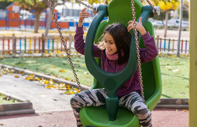 Girl sitting on swing at park