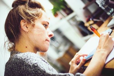 Side view of young woman working on desk