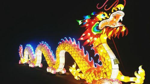 Low angle view of illuminated lights against sky at night