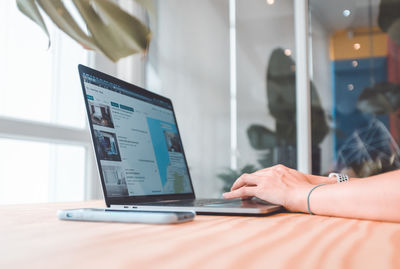 Midsection of man using laptop on table