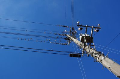 Low angle view of electricity pylon against clear sky