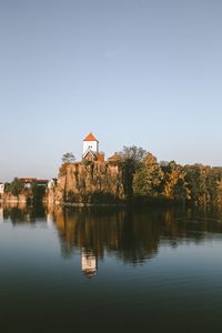 Scenic view of lake by building against clear sky