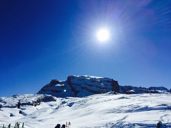 Scenic view of snow covered mountains against blue sky