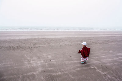 Full length of child on beach against sky