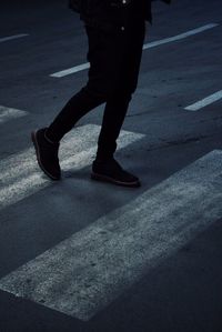 Low section of man standing on road