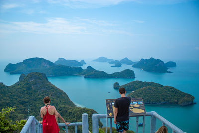 Rear view of people on observation point against sea