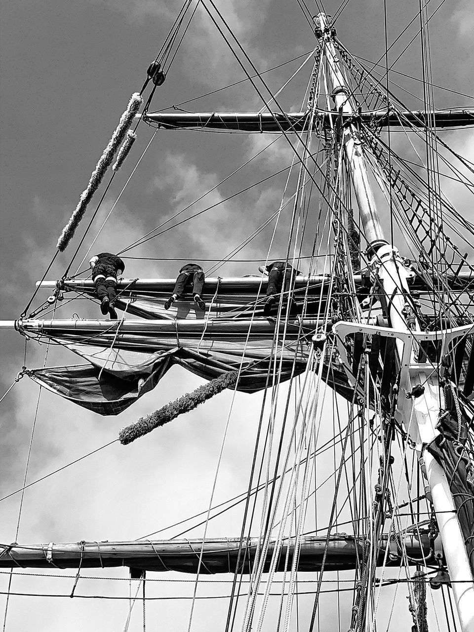 LOW ANGLE VIEW OF FERRIS WHEEL AGAINST SKY WITH BOATS