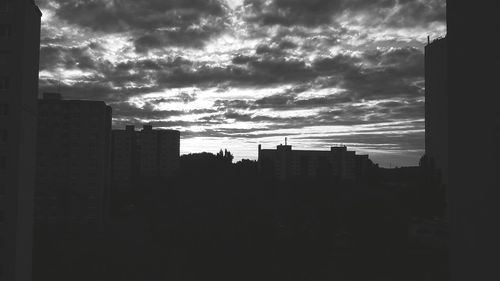 Buildings in city against cloudy sky