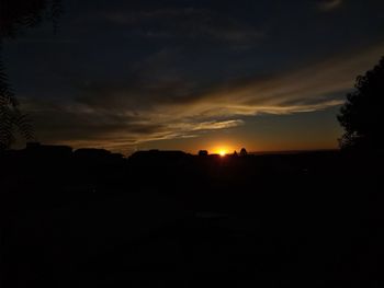 Scenic view of silhouette landscape against orange sky