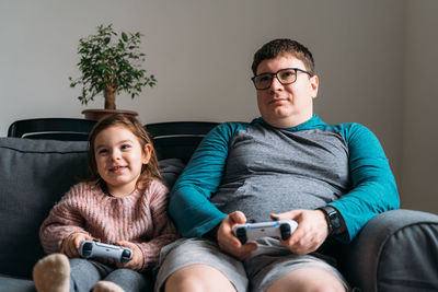 High angle view of friends sitting on sofa