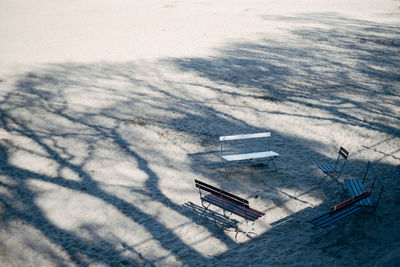 High angle view of benches on sand at beach