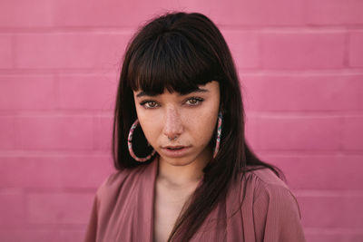 Portrait of young woman against wall