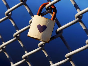 Close-up of padlocks on chainlink fence