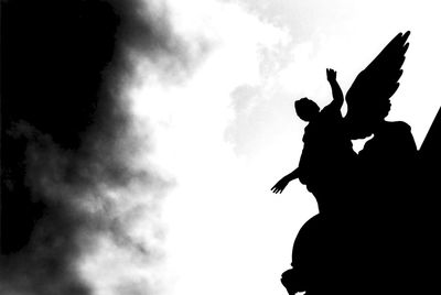Low angle view of silhouette statue against sky