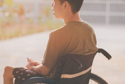 Side view of man sitting on wheelchair