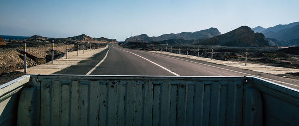 Road leading towards mountains against sky