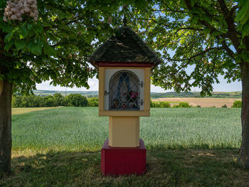 Information sign on field against trees