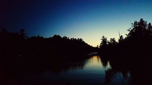 Scenic view of lake against clear sky during sunset