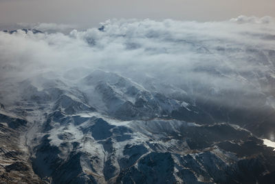 Aerial view of snowcapped mountains against sky