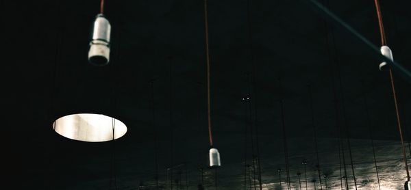 Low angle view of illuminated light bulbs hanging from ceiling