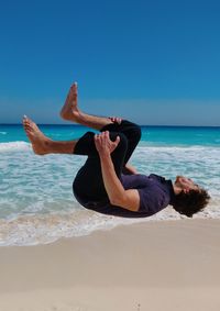 Black flip  parkour at sea against sky