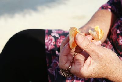 Close-up of hands holding orange slices