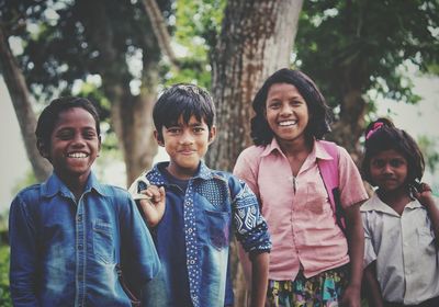 Portrait of happy friends standing in forest