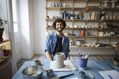 Portrait of smiling man sitting in pottery class