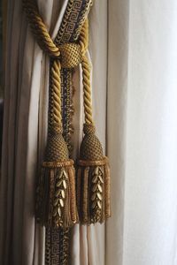 Close-up of tassels hanging by curtain