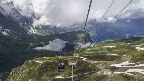 Overhead cable car over mountain against sky