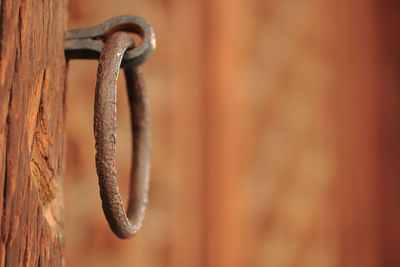 Close-up of rusty metal hanging on wood