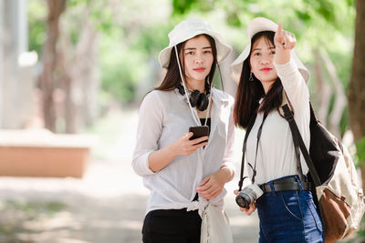 Young woman using mobile phone while standing outdoors