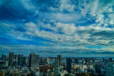 Aerial view of buildings in city against sky