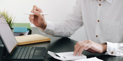 Midsection of man working on table