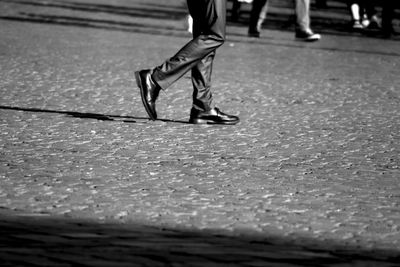 Low section of woman walking on road