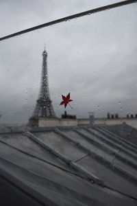 Close-up of wet window against sky