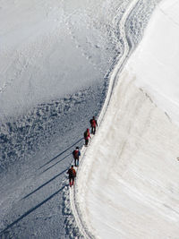 High angle view of people walking in snow covered landscape