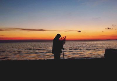 Silhouette of man on beach at sunset