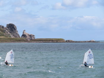 People windsurfing on sea