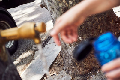 Cropped image of person filling water bottle
