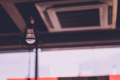 Low angle view of illuminated pendant lights hanging in building