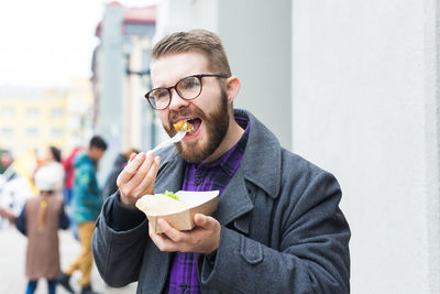 Portrait of young man eating food