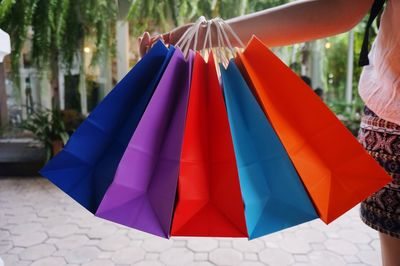 Midsection of woman holding colorful shopping bags